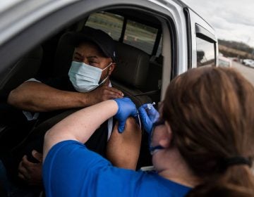 A nurse administers a shot at a COVID-19 mass vaccination site at Martinsville speedway