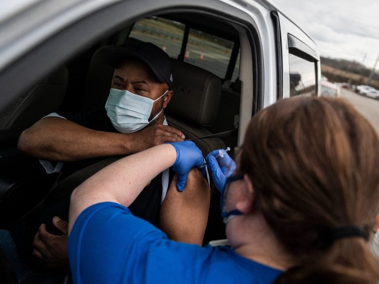 A nurse administers a shot at a COVID-19 mass vaccination site at Martinsville speedway