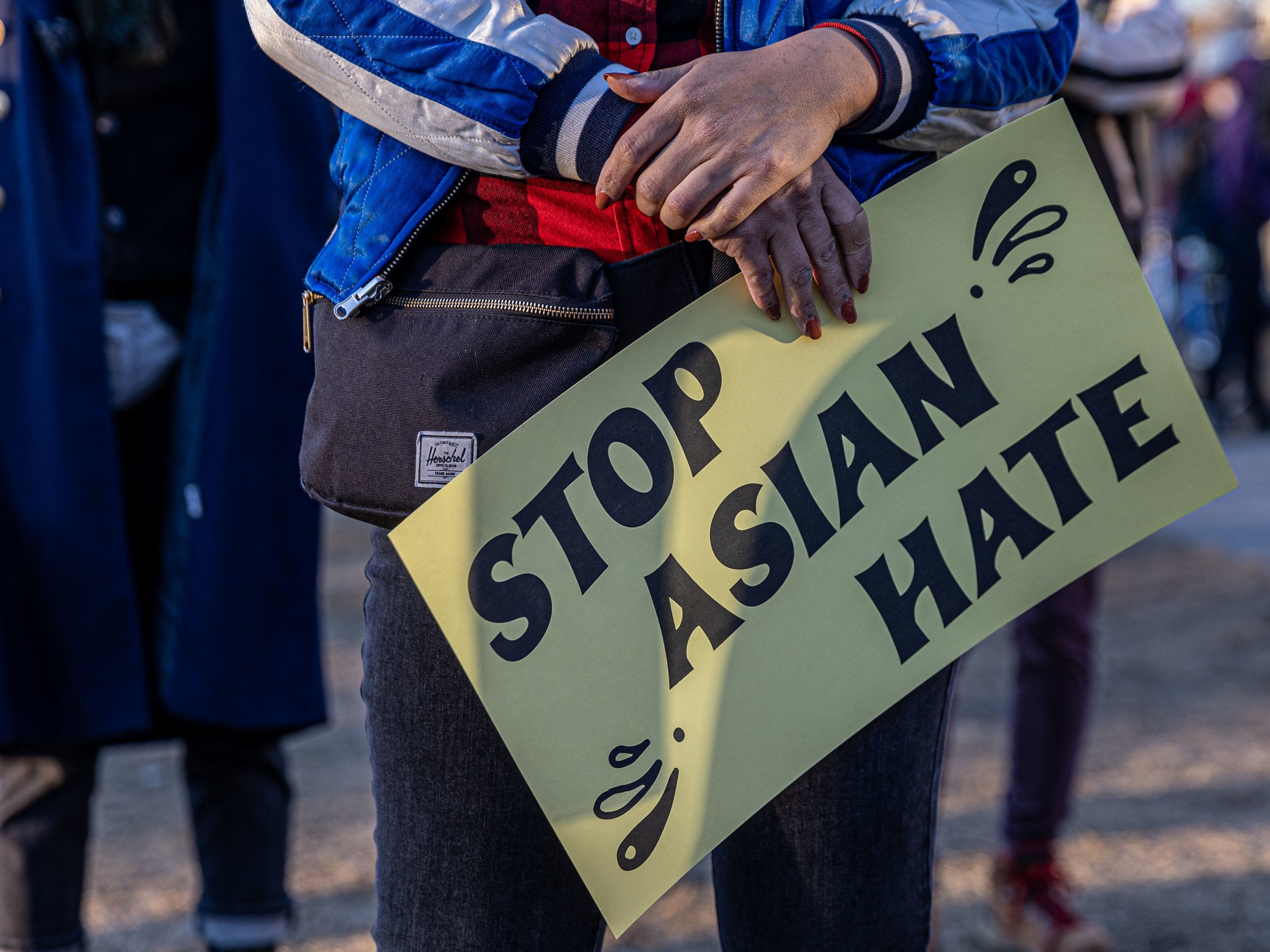 A person holds a sign during the "Asian Solidarity March" rally against recent anti-Asian crime