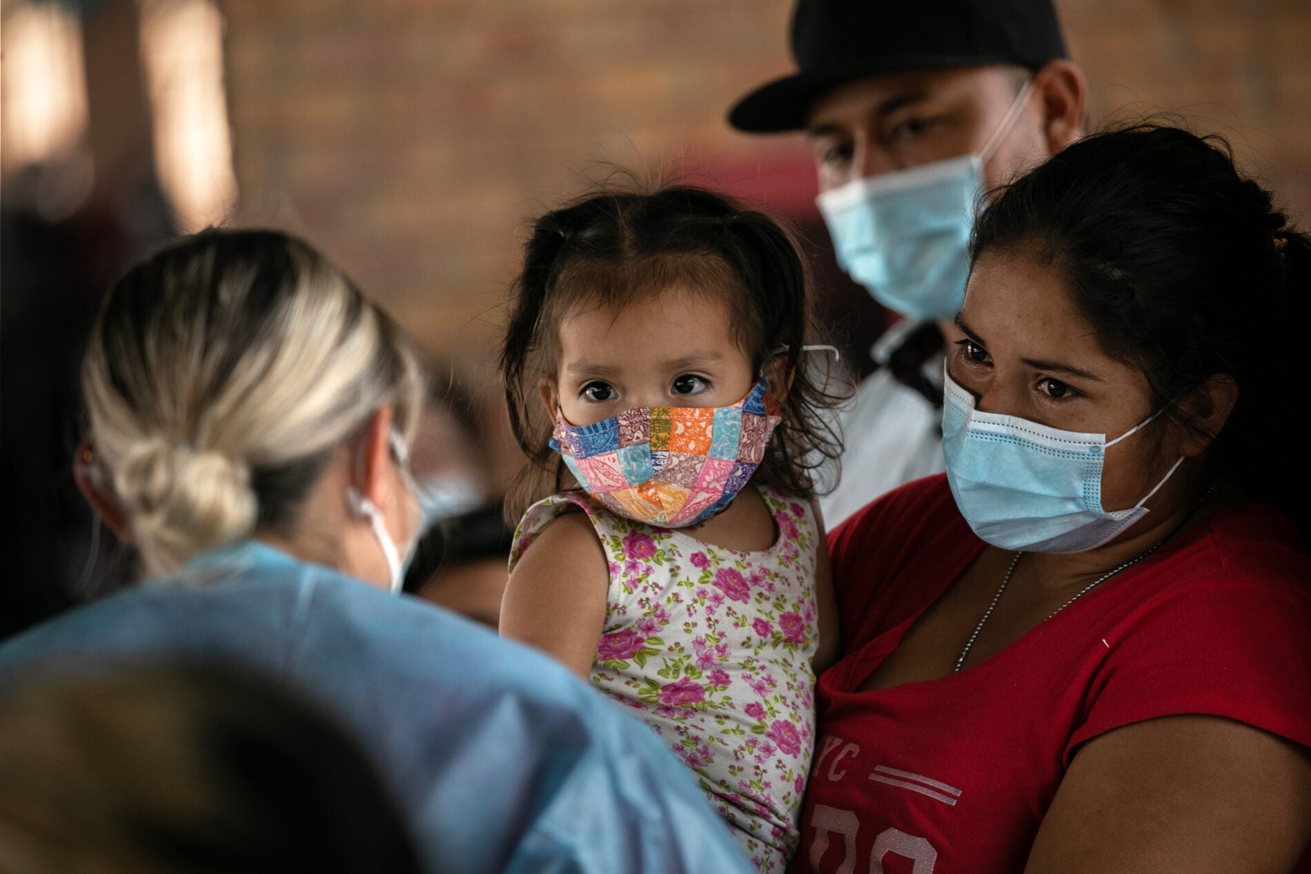 An immigrant mother holds her daughter while awaiting Covid-19 test results on last month after being released by U.S. immigration authorities in Brownsville, Texas.