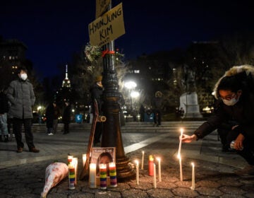 A person lights candles during a peace vigil to honor victims of attacks on Asian Americans