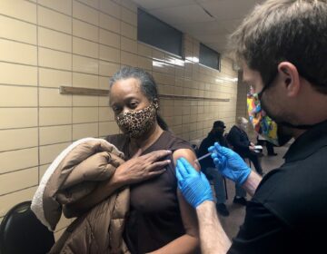 Dr. Rick Pescatore, chief physician at the Delaware Division of Public Health, gives a shot of the Pfizer vaccine to Brenda Jones at the Rose Hill Community Center. (Cris Barrish/WHYY)