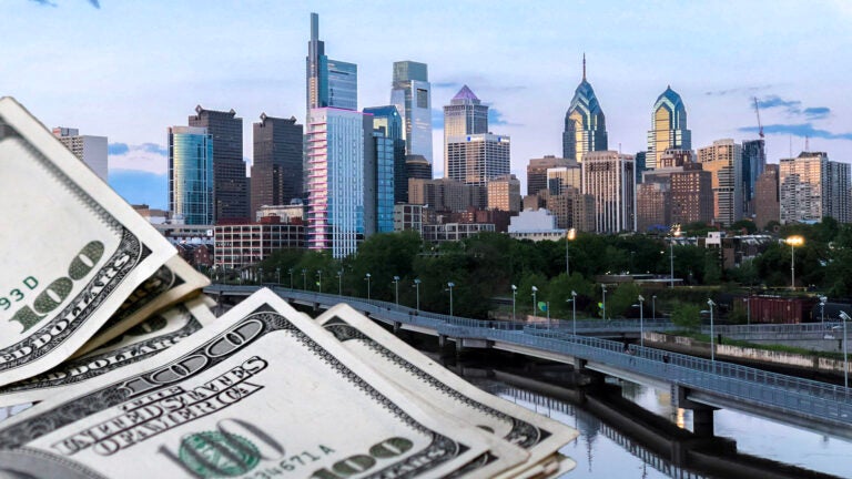 Piles of money are illustrated alongside Philly's skyline