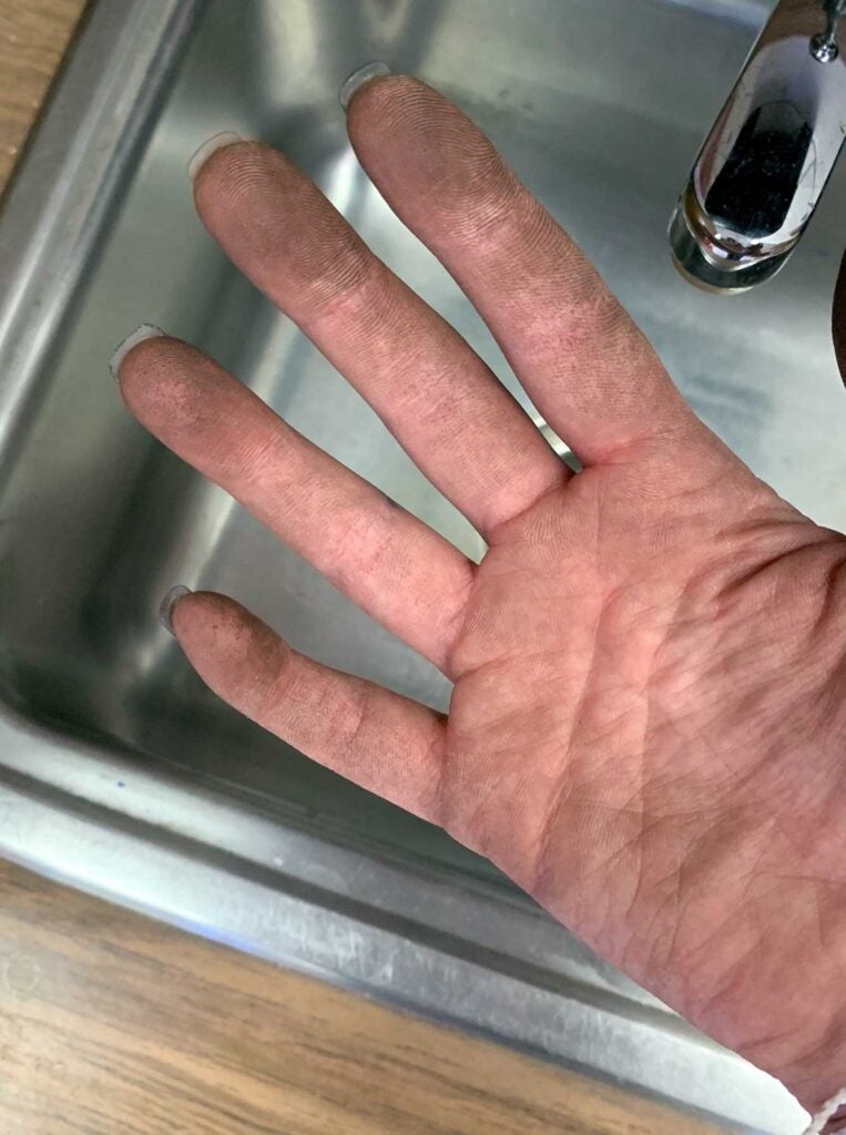 Rutherford's hands covered in dust after cleaning her classroom