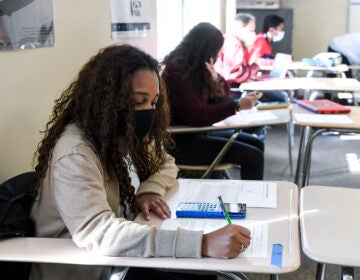 Giani Clarke, 18, a senior at Wilson High School in West Lawn, Pa., takes a test in her AP statistics class earlier this month. The desks are doubled as a way to provide more social distancing. (MediaNews Group/Reading Eagle vi/MediaNews Group via Getty Images)