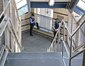 SEPTA police officers stand guard in the freshly cleaned stairwell at Somerset Station on the Market-Frankford line. (Emma Lee/WHYY)