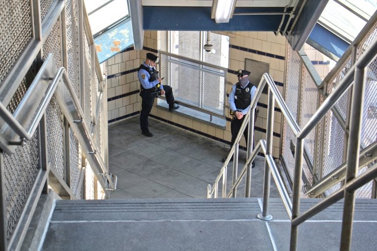 SEPTA police officers stand guard in the freshly cleaned stairwell at Somerset Station on the Market-Frankford line. (Emma Lee/WHYY)