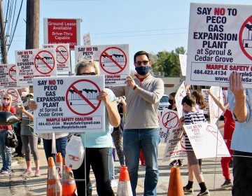 Greg Fat (center), a leader of Marple Safety Coalition, joins protesters at the intersection of Sproul and Cedar Grove roads in Marple Township, Pa, where PECO wants to build a natural gas expansion plant. (Emma Lee/WHYY)