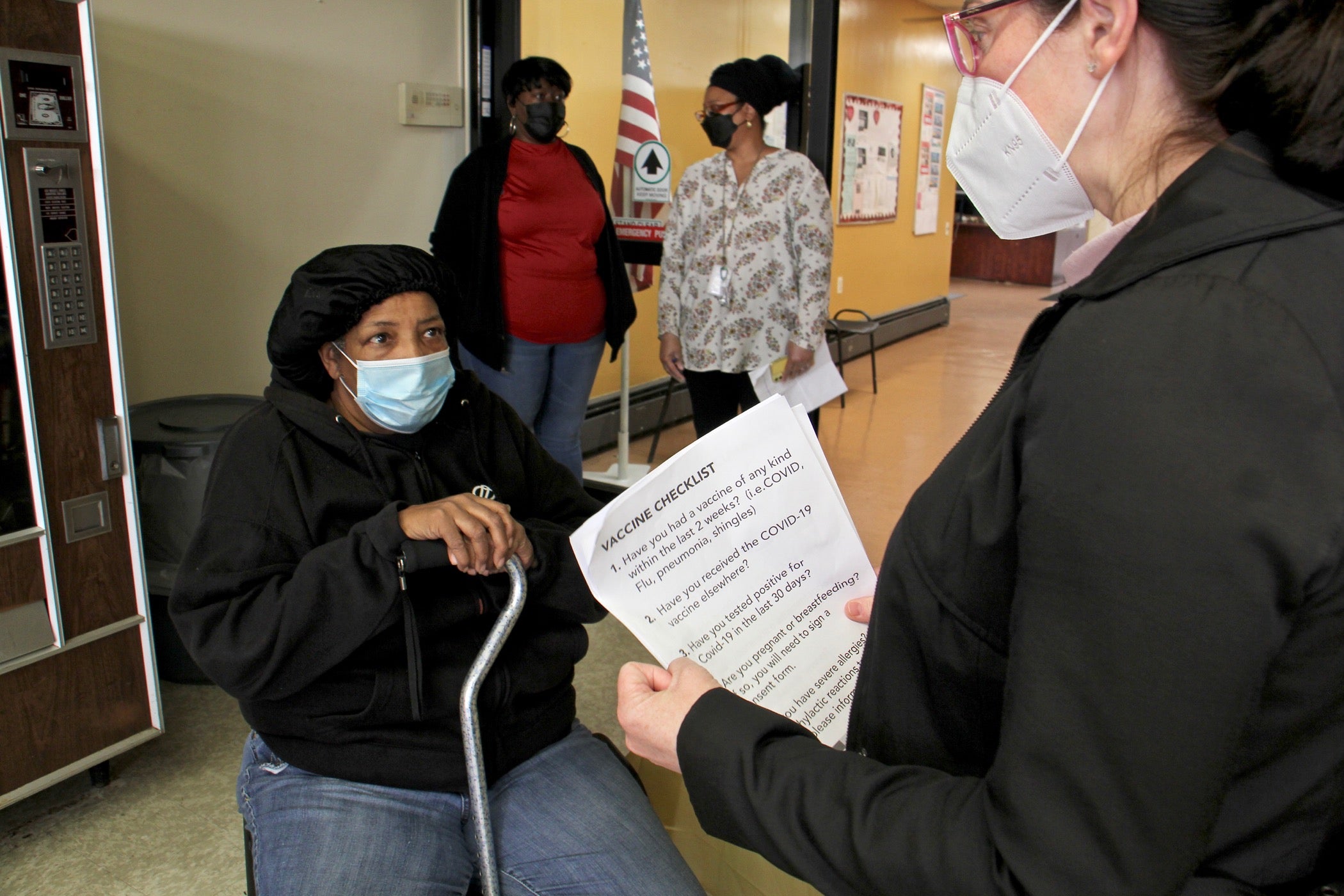 Deloris Barham, 71, answers a series of health questions before receiving her COVID-19 vaccination