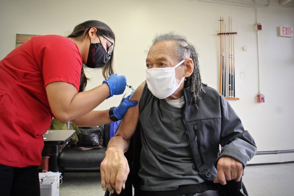 Ekay Brown, 76, of Camden, gets his COVID-19 vaccination from Leslie Demark