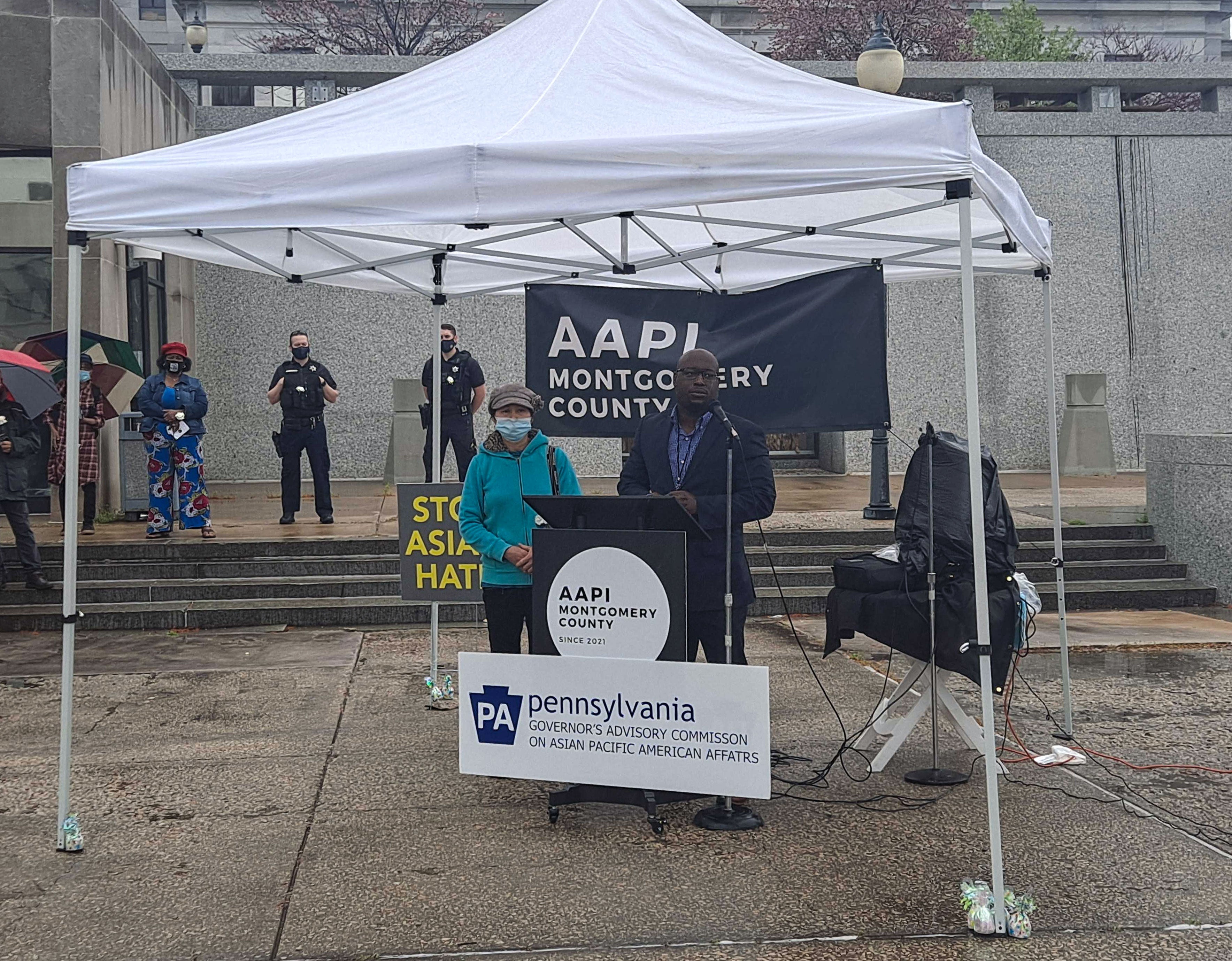 Ying Ngov and City Councilman Hakim Jones stand by a podium at a vigil in support of the AAPI community