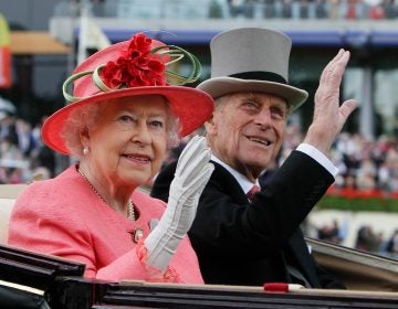 Queen Elizabeth II with Prince Philip arrive by horse drawn carriage