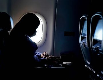 A passenger wears a face mask during an airline flight