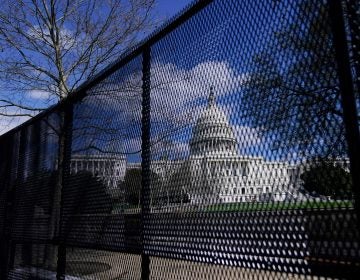 The U.S. Capitol is seen behind security fencing after a car that crashed into a barrier on Capitol Hill in Washington, Friday, April 2, 2021.