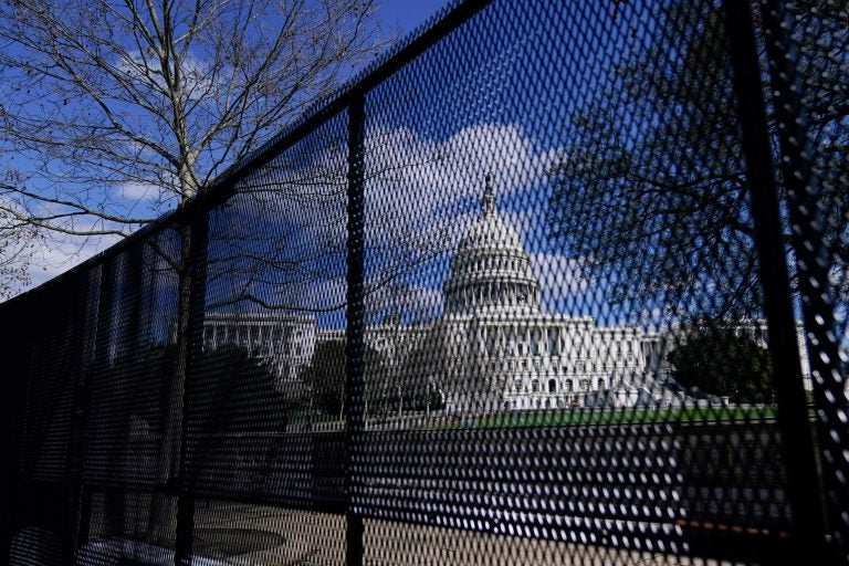 The U.S. Capitol is seen behind security fencing after a car that crashed into a barrier on Capitol Hill in Washington, Friday, April 2, 2021.