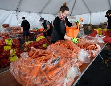 FILE - In this April 18, 2020, file photo, San Francisco-Marin Food Bank volunteers pack food into bags to be delivered to people in San Francisco. About 25 million Americans will be eligible for more food assistance money under a new policy adopted by President Joe Biden's administration under a change announced Thursday, April 1, 2021. (AP Photo/Jeff Chiu, File)