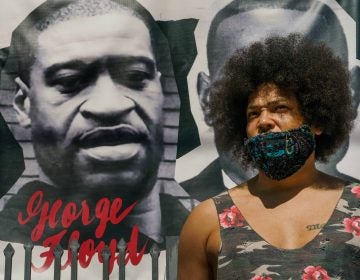 Actor Steven Thompson poses for a picture next to a poster of George Floyd in Los Angeles Friday, April 2, 2021. (AP Photo/Damian Dovarganes)