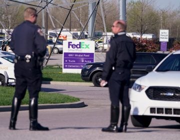 Police stand near the scene where multiple people were shot at the FedEx Ground facility early Friday morning, April 16, 2021, in Indianapolis. A gunman killed eight people and wounded several others before apparently taking his own life in a late-night attack at a FedEx facility near the Indianapolis airport, police said, in the latest in a spate of mass shootings in the United States after a relative lull during the pandemic. (AP Photo/Michael Conroy)