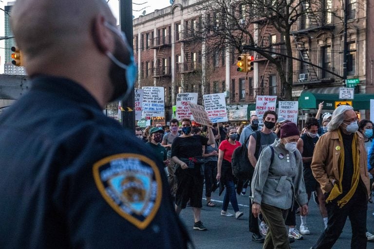 Police officers keep a watchful eye as peaceful protesters march down Flatbush Avenue on Tuesday, April 20, 2021, in the Brooklyn borough of New York. Former Minneapolis police Officer Derek Chauvin has been convicted of murder and manslaughter in the death of George Floyd, the explosive case that triggered worldwide protests, violence and a furious reexamination of racism and policing in the U.S. Floyd died last May after Chauvin, a white officer, pinned his knee on or close to the 46-year-old Black man's neck for about 9 1/2 minutes. (AP Photo/Brittainy Newman)