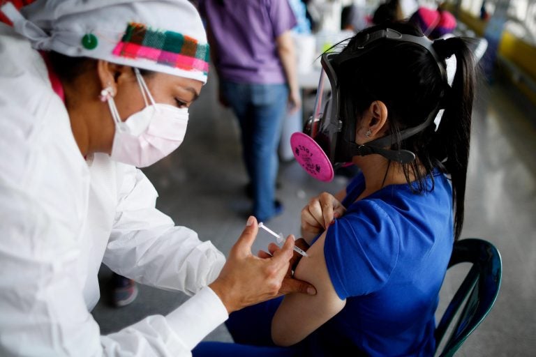 In this April 23, 2021, file photo, a health care worker inoculates Dr. Virma Rivas with the Sputnik V COVID-19 vaccine, as part of a vaccination campaign in Tegucigalpa, Honduras. (AP Photo/Elmer Martinez)