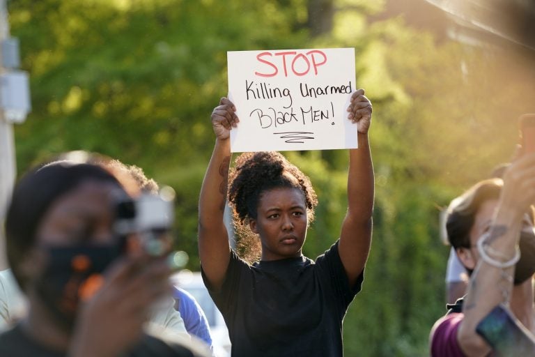 A person holds up a sign that says 