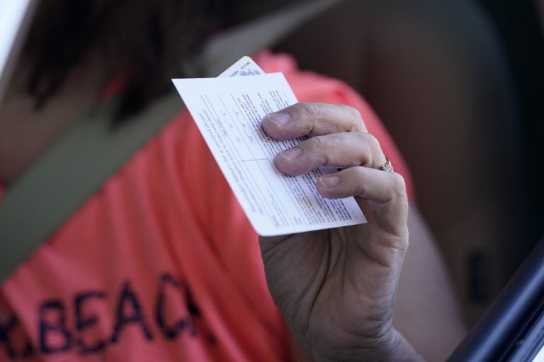 Sandy Boeckl holds her inoculation card