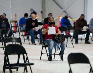 People sit in an observation area after being inoculated with the Johnson & Johnson COVID-19 vaccine