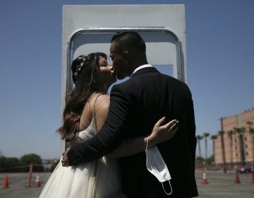 Roselle Querido, left, and her groom Mo de las Alas kiss after their marriage service