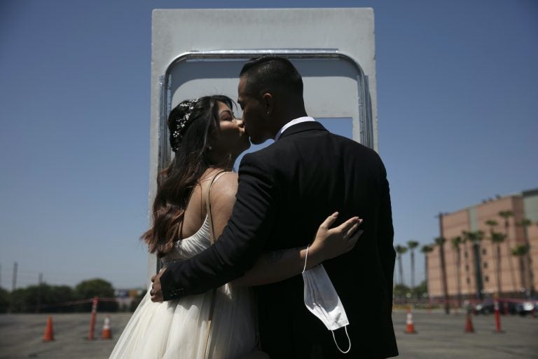 Roselle Querido, left, and her groom Mo de las Alas kiss after their marriage service