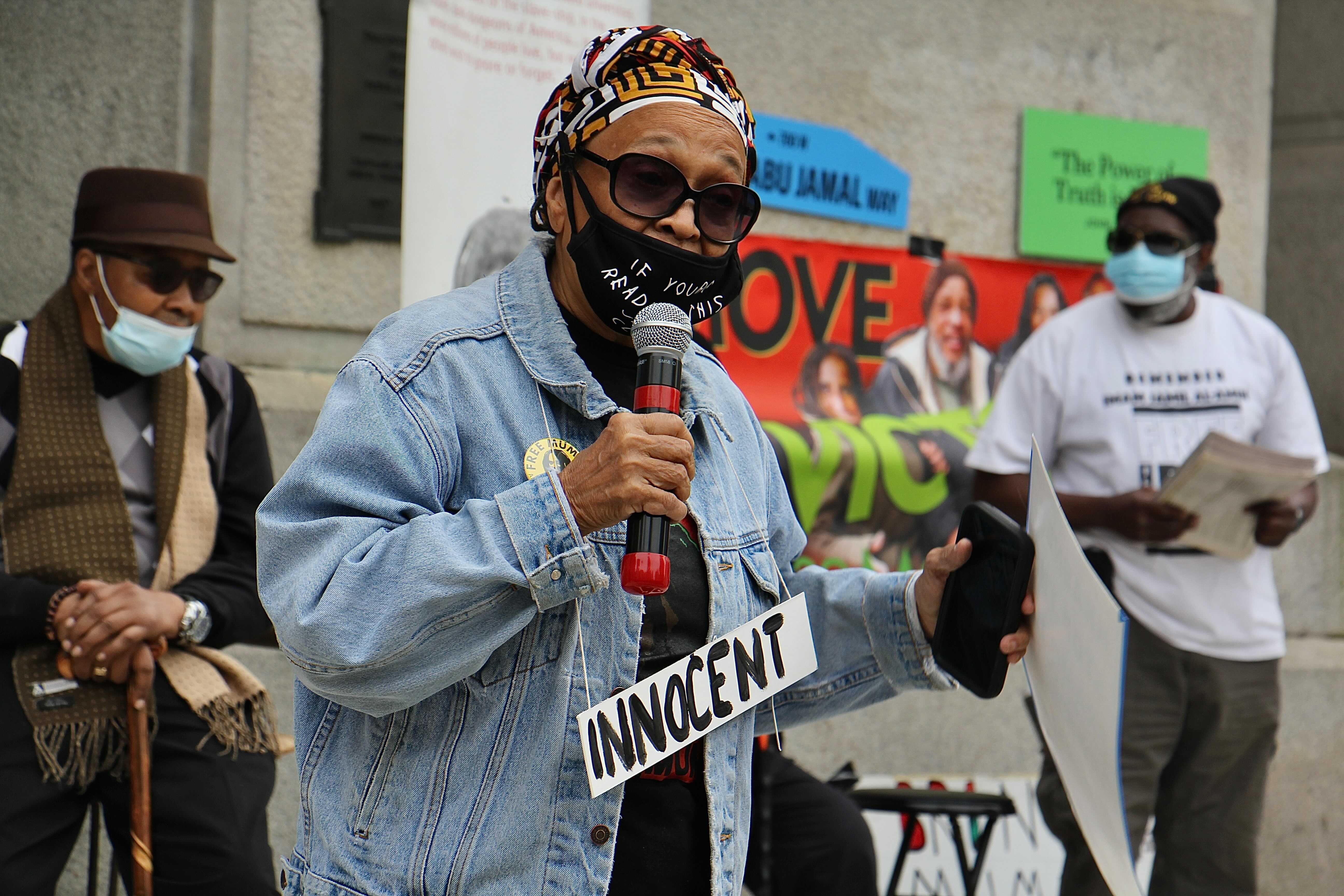 Pam Africa calls for the release of Mumia Abu-Jamal during a rally at City Hall. (Emma Lee/WHYY)