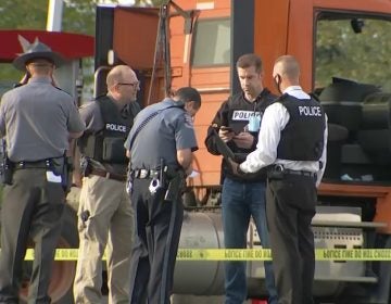 Law enforcement gathers outside a Wawa, where a gunman fired at a man pumping gas