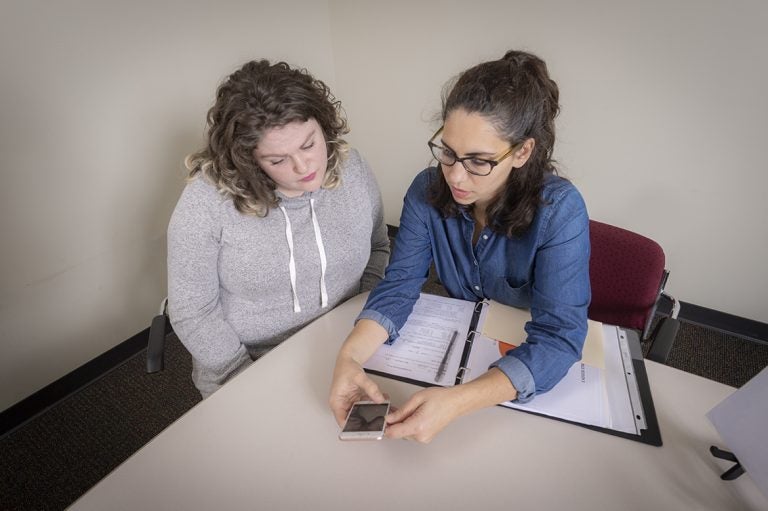 Amanda Rabinowitz (right), director of the Brain Injury Neuropsychology Laboratory at the MossRehab Research Institute, demonstrates the RehaBot. (courtesy of MossRehab Research Institute)