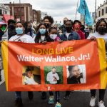 Protesters carry a banner in honor of Walter Wallace Jr.