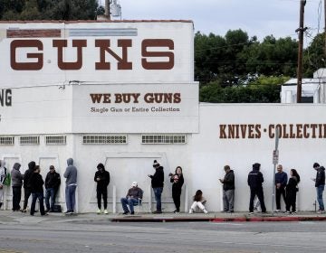 People wait in line to enter a gun store in Culver City