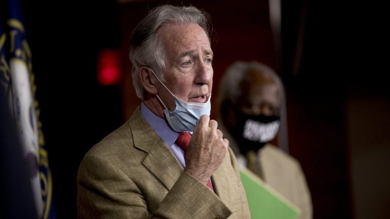 Richard Neal pulls down his face mask