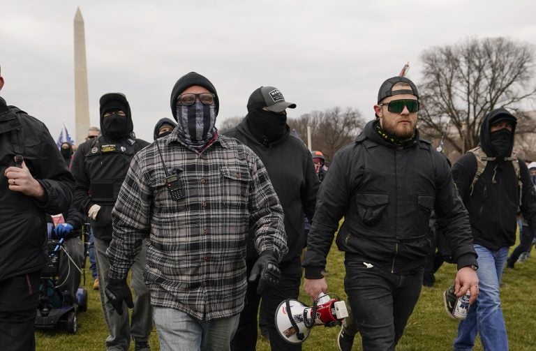 Proud Boy members Joseph Biggs (left) and Ethan Nordean, carrying a megaphone, walk toward the U.S. Capitol on Jan. 6. A federal judge ordered them detained pending trial given the conspiracy charges against them. (Carolyn Kaster/AP)