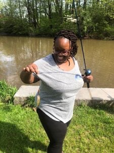 Ariane Thomas holds up a fish on a fishing line