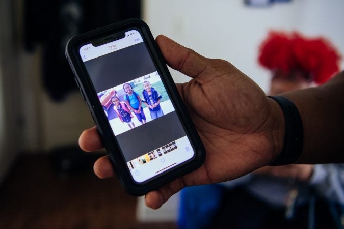 Jonathan showing a photograph of their chidlren on his phone.