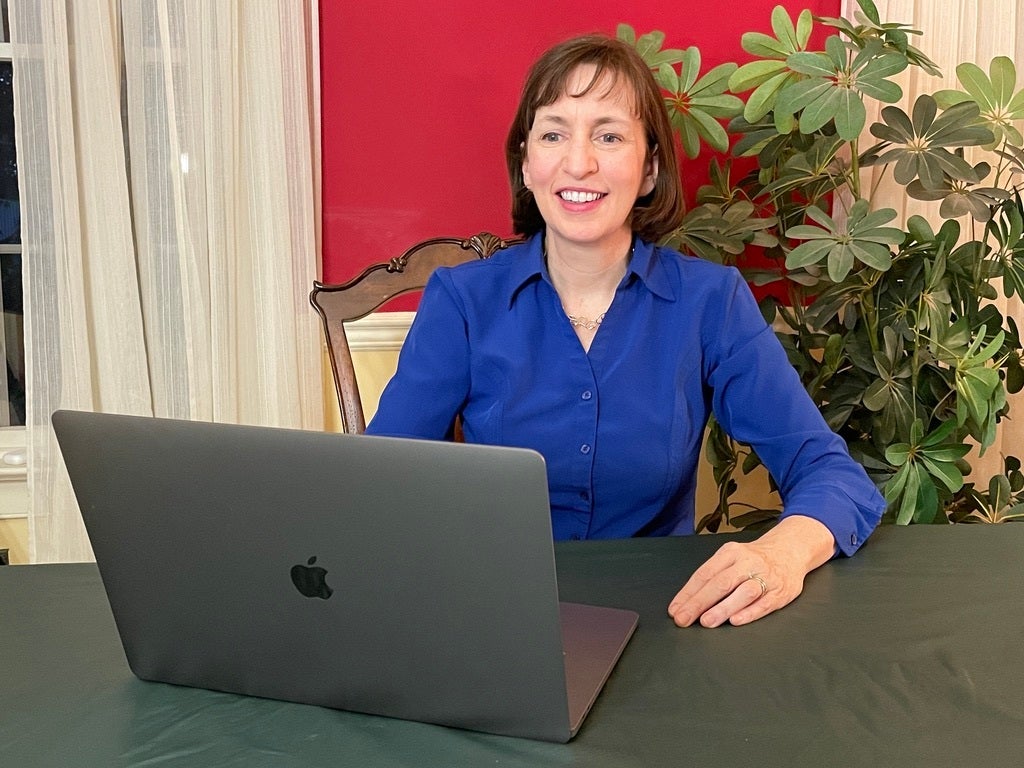 Eileen Kennedy-Moore smiles while sitting behind her laptop