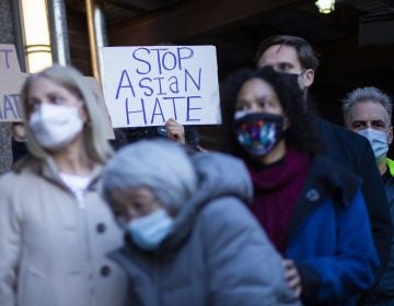 People attend an anti-violence press conference on Tuesday outside the building where a 65-year-old Asian woman was attacked in New York.