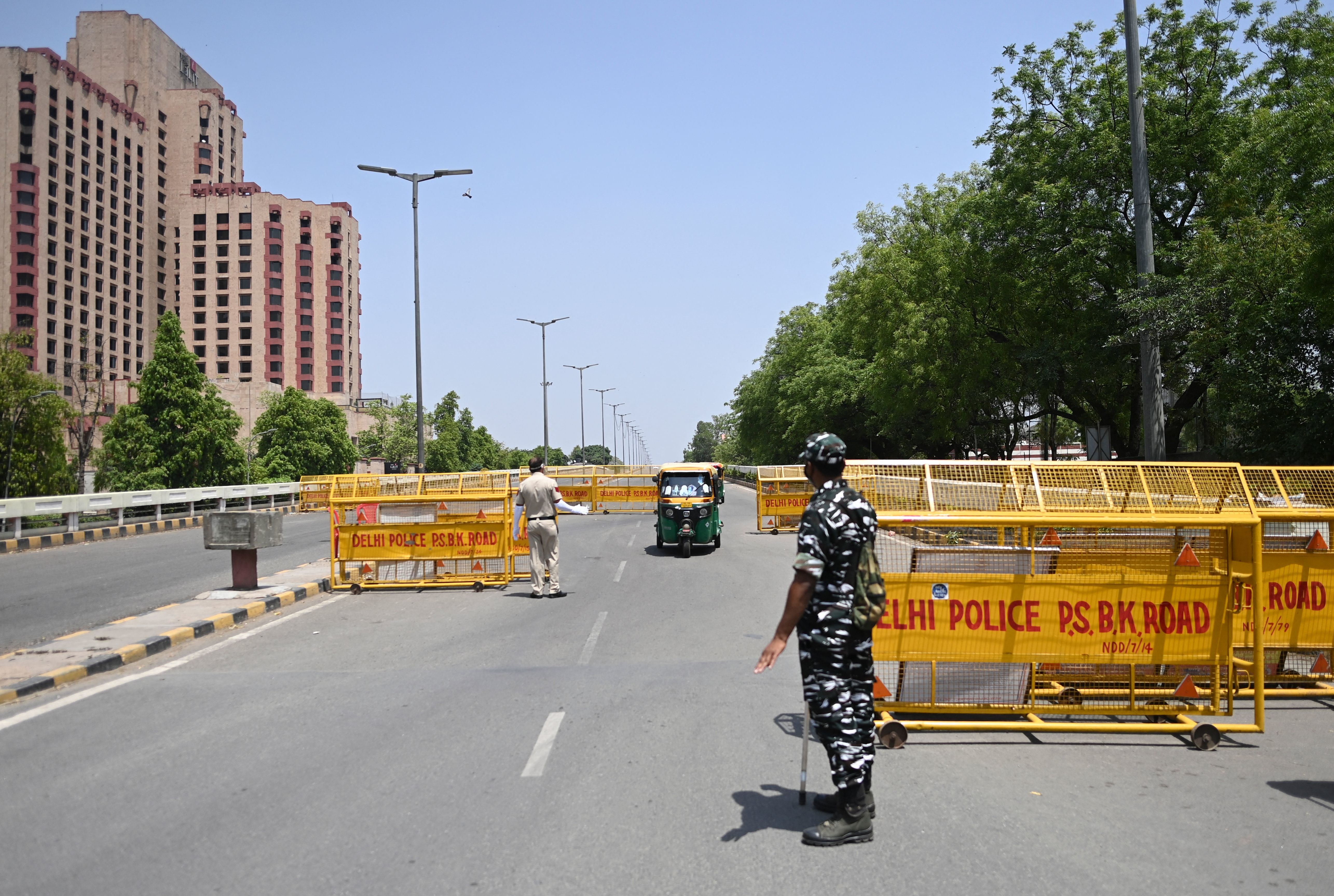 Police stop vehicles April 18 at a New Delhi checkpoint aimed at enforcing a weekend lockdown