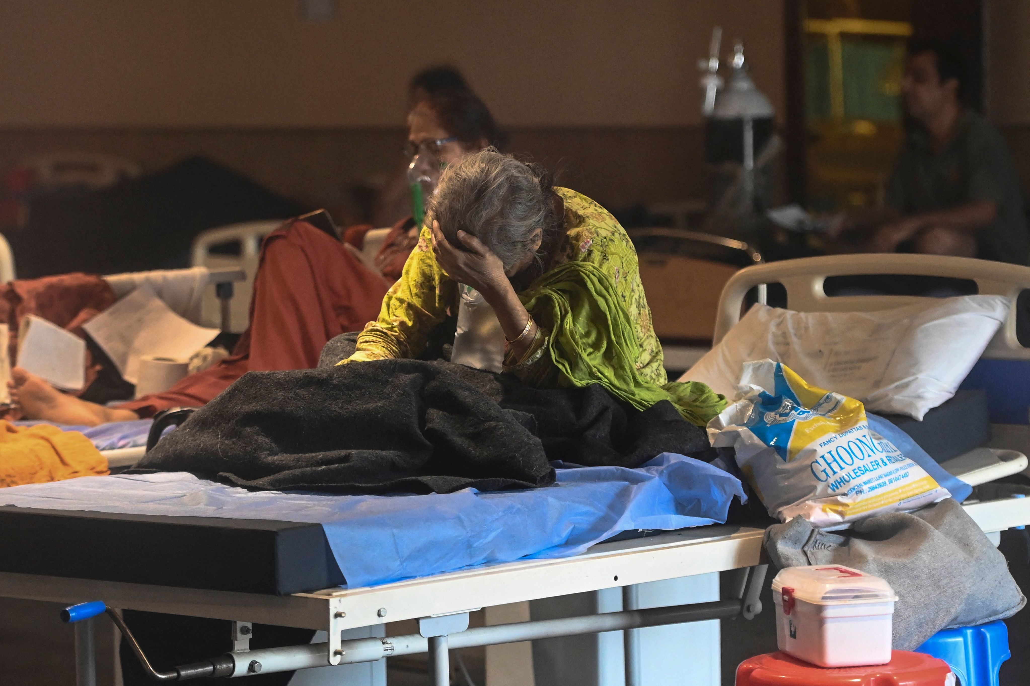 A patient rests inside a banquet hall converted into a COVID-19 ward