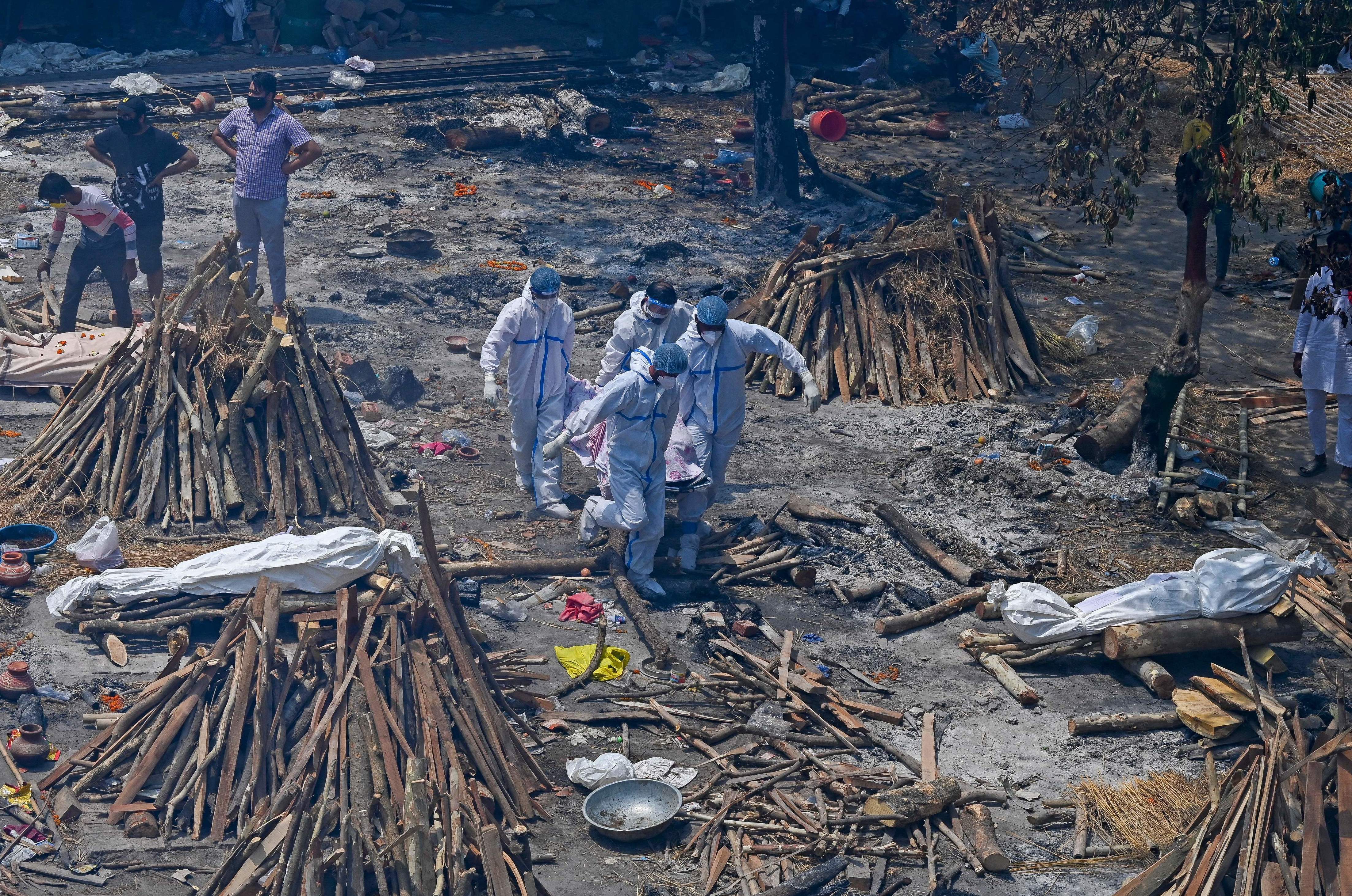 Relatives perform last rites amid funeral pyres during a mass cremation