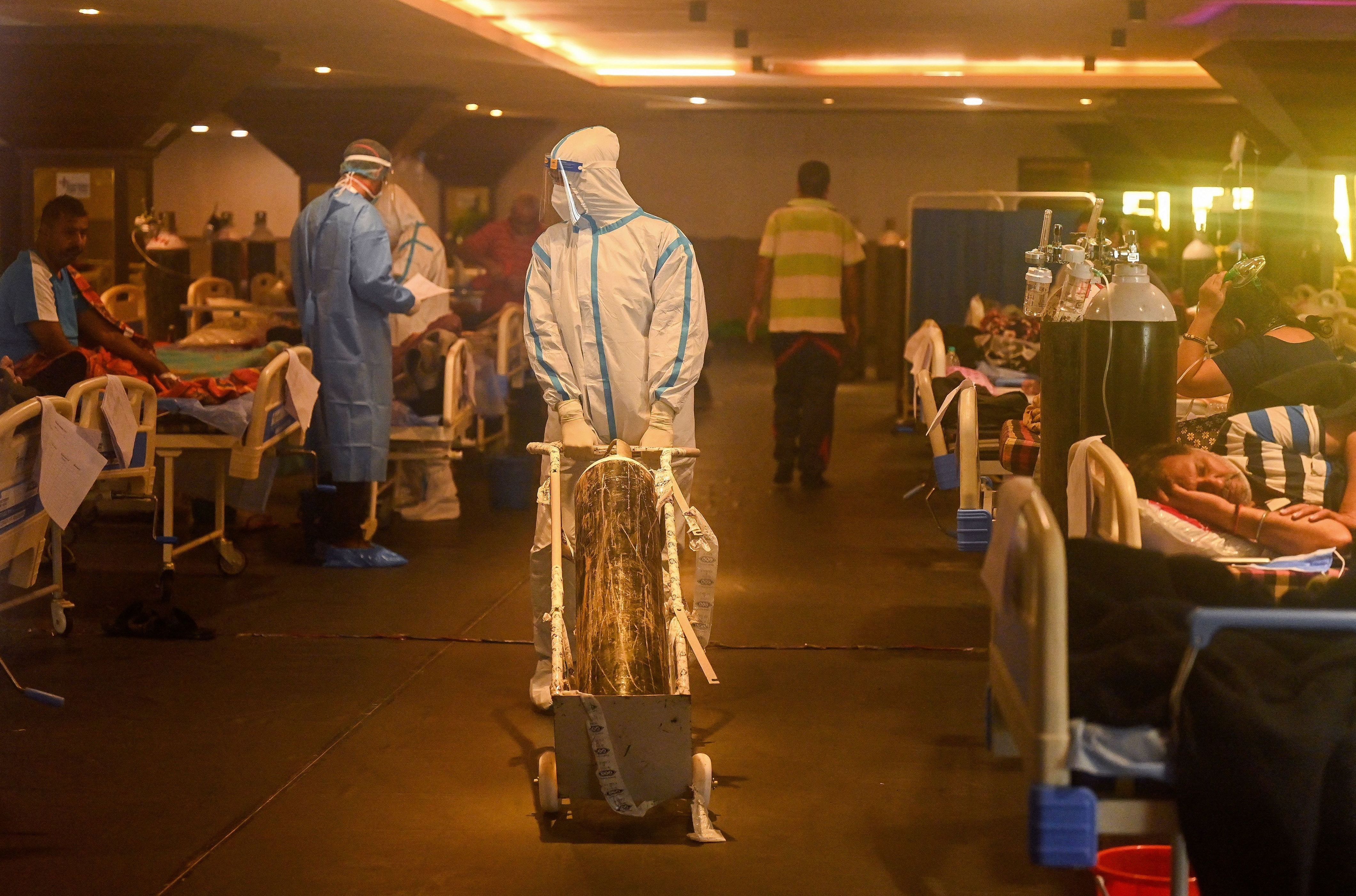 Health workers in protective gear tend to patients Wednesday in a banquet hall temporarily converted into a COVID-19 care center