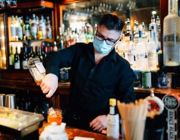 A bartender makes a drink