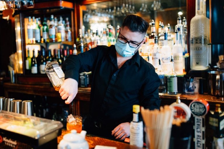 A bartender makes a drink