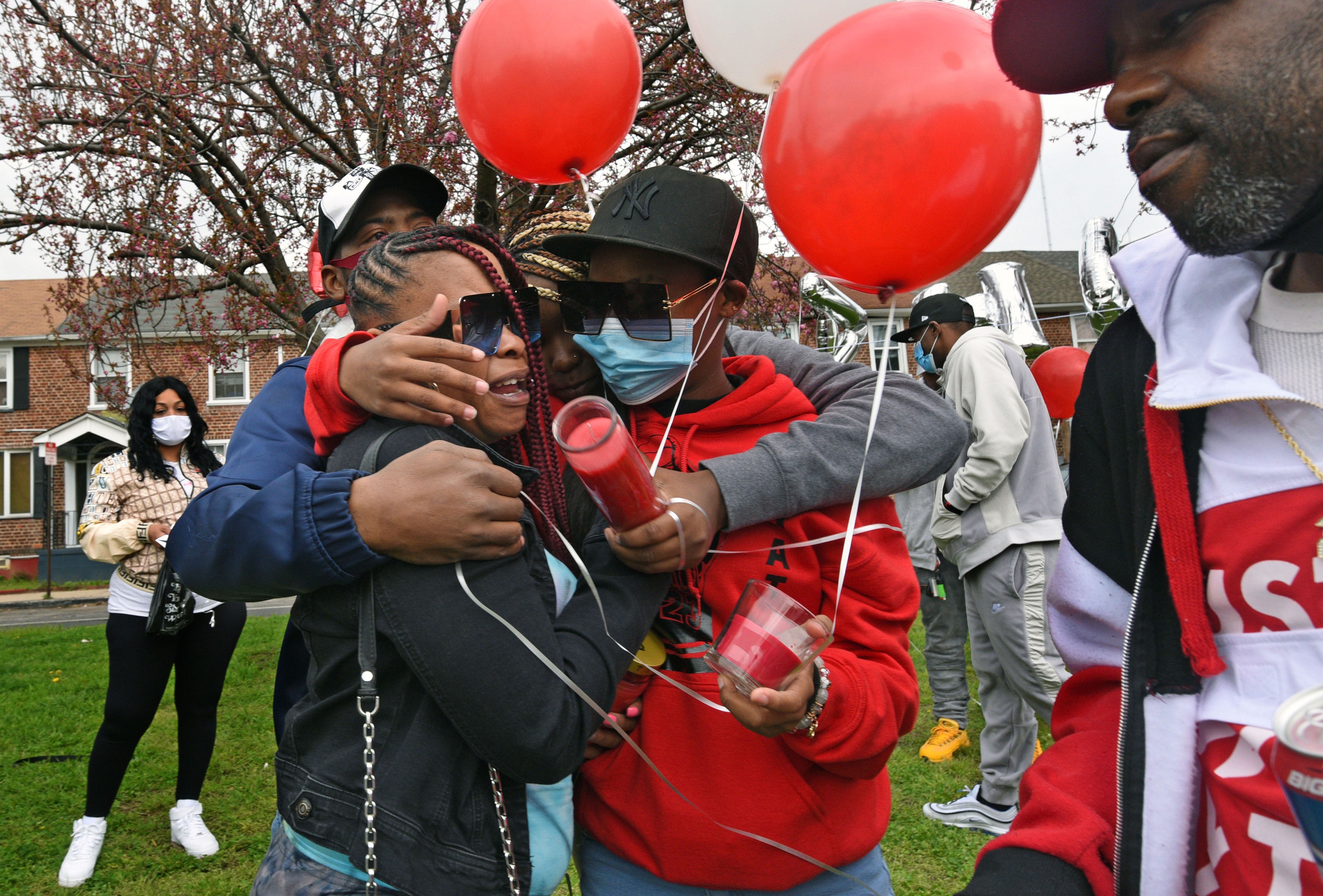 Tomeka Holmes (left) is embraced by family members, including her 15-year-old daughter Siani Custis