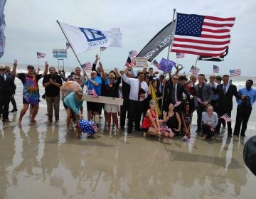 Businesspeople in suits and dresses go into the Atlantic Ocean as part of opening ceremonies in Ocean City, N.J. (Tom MacDonald/WHYY)