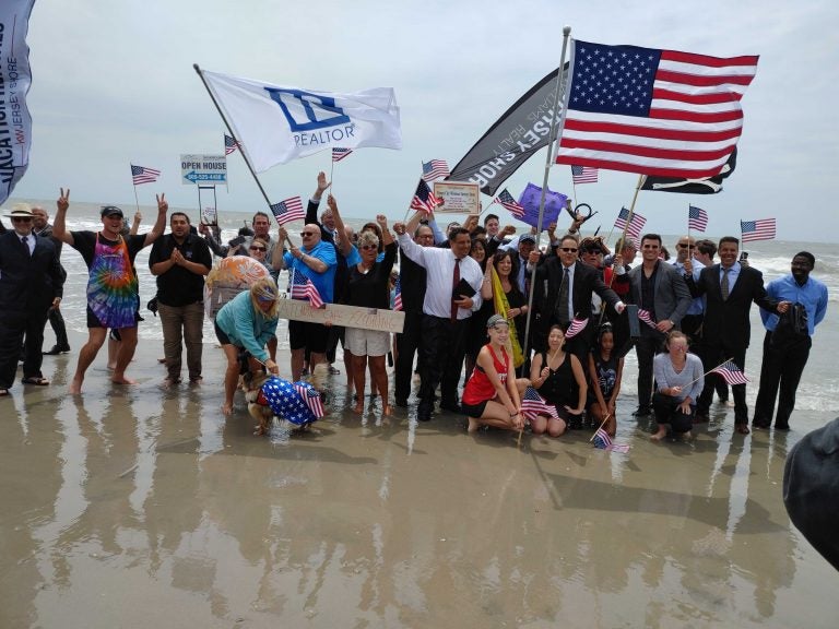 Businesspeople in suits and dresses go into the Atlantic Ocean as part of opening ceremonies in Ocean City, N.J. (Tom MacDonald/WHYY)