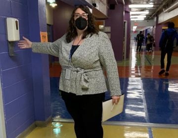 Margaux Munnelly, principal Mastery Charter School-Pickett Campus in Germantown, uses the hand sanitizer station in the hallway. (Dale Mezzacappa/Chalkbeat Philadelphia)